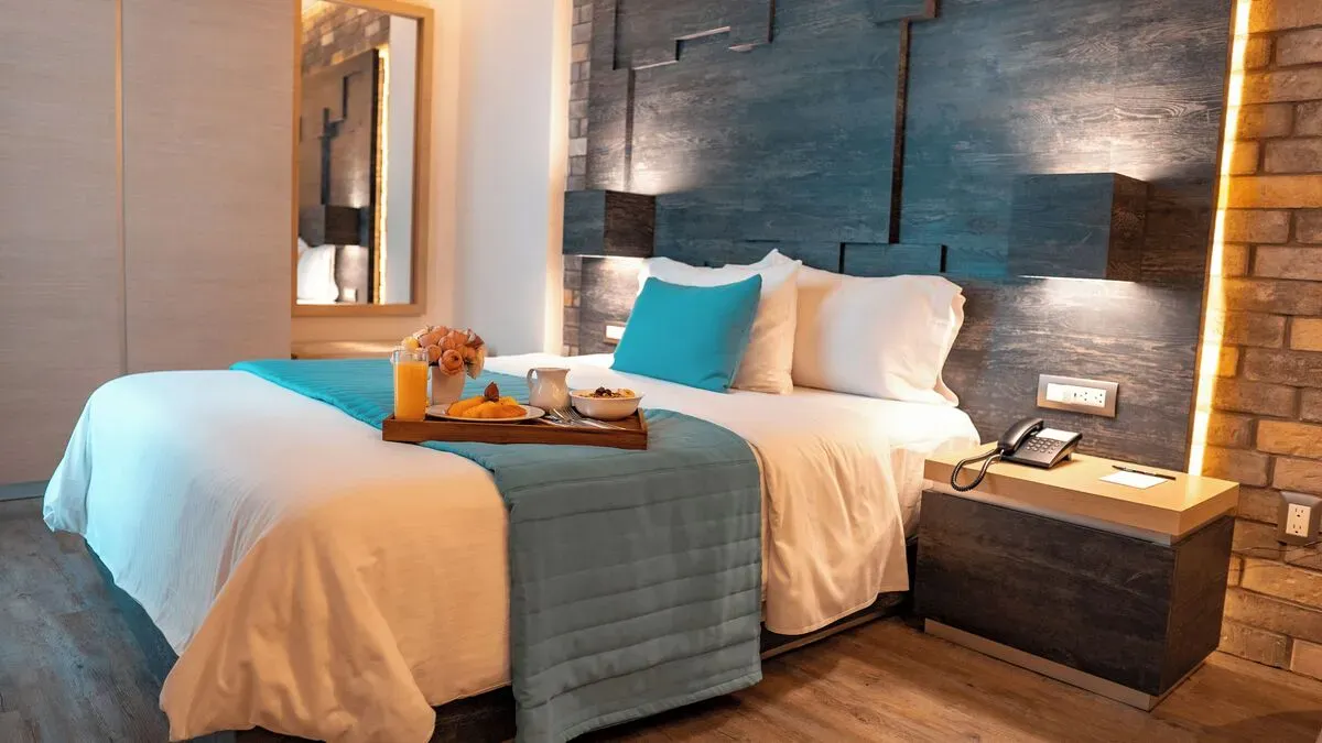Executive-номер с двуспальной кроватью в Hotel Punto MX. На кровати поднос с завтраком.