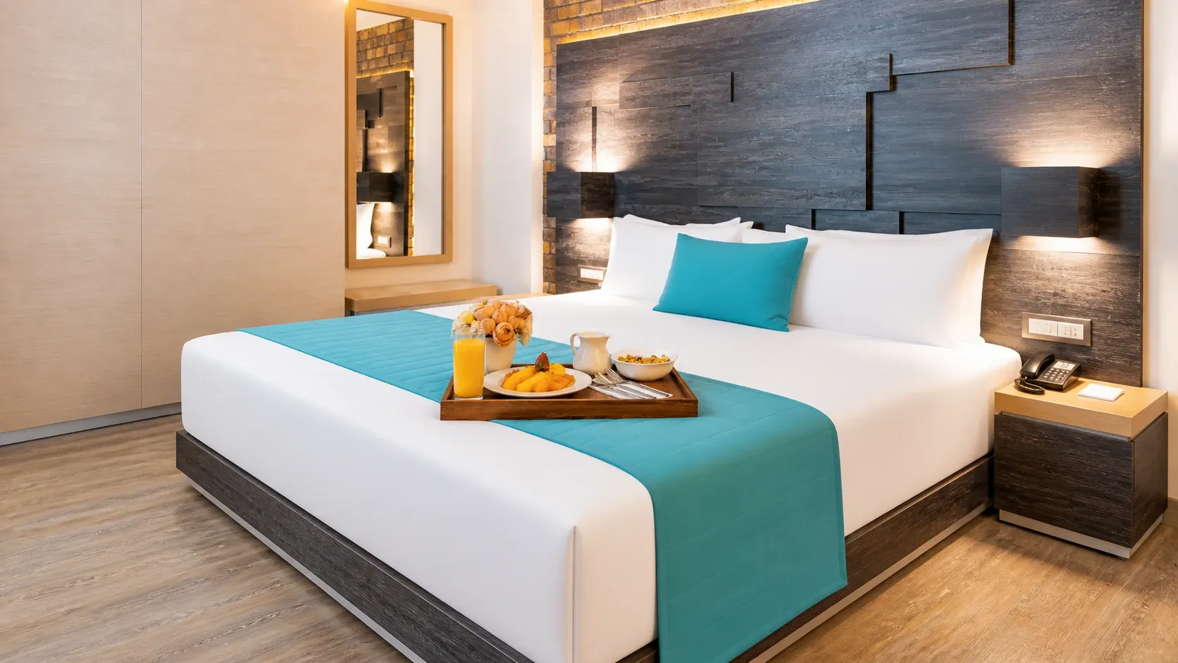 Habitación Ejecutiva con cama matrimonial en el Hotel Punto MX. Se ve una charola con el desayuno en la cama.