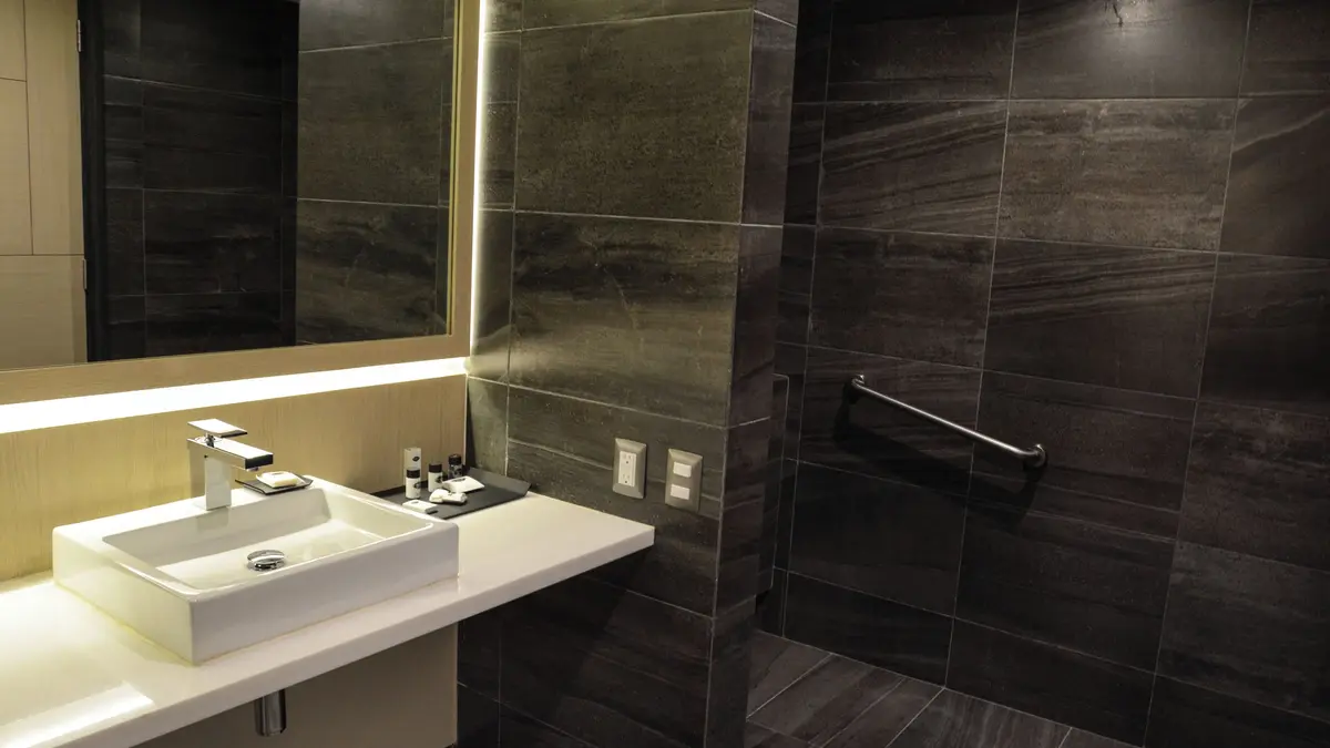 Banheiro do quarto Suite Junior Interior com cama de casal no Hotel Punto MX.