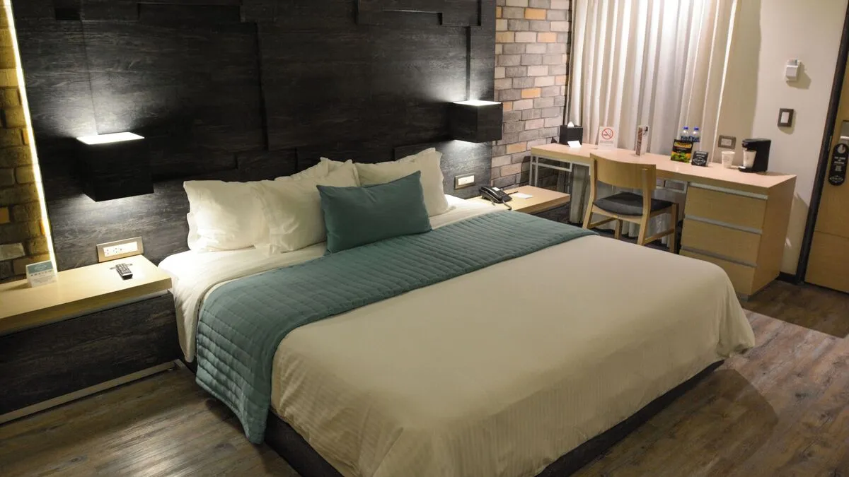 ホテル・プントMXのジュニアスイート(室内、キングベッド)。ワークデスクとコーヒーメーカーが見えます。