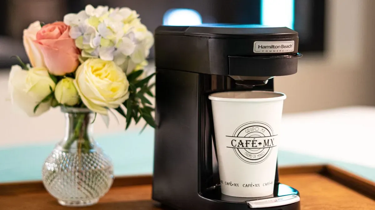 Coffee maker in the Master Suite at Hotel Punto MX with a coffee cup with the Hotel Punto MX logo.