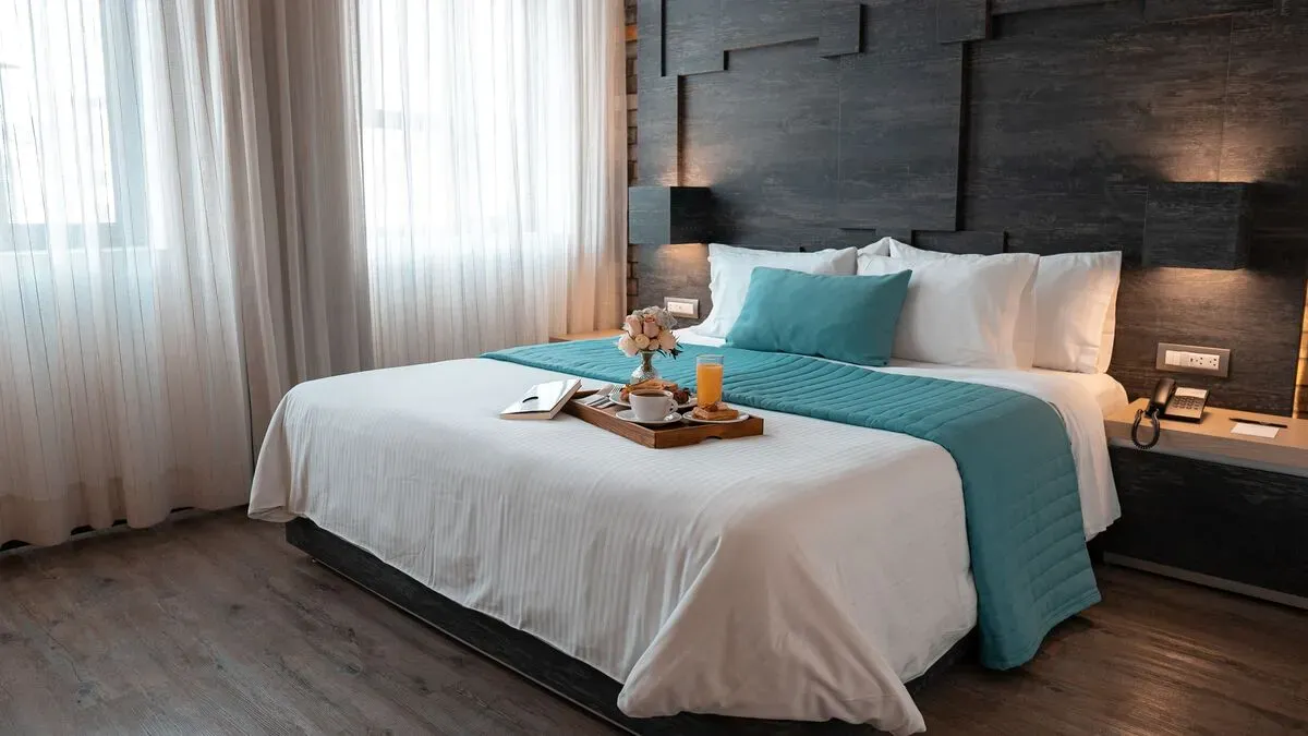 Jacuzzi Suite with king-size bed at Hotel Punto MX. A breakfast tray is on the bed.